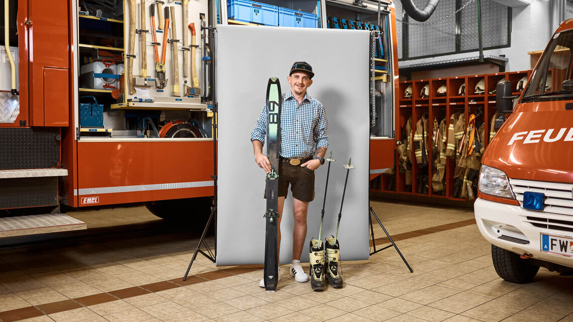 Martin in Lederhosen und mit Skiern in der Feuerwache.
