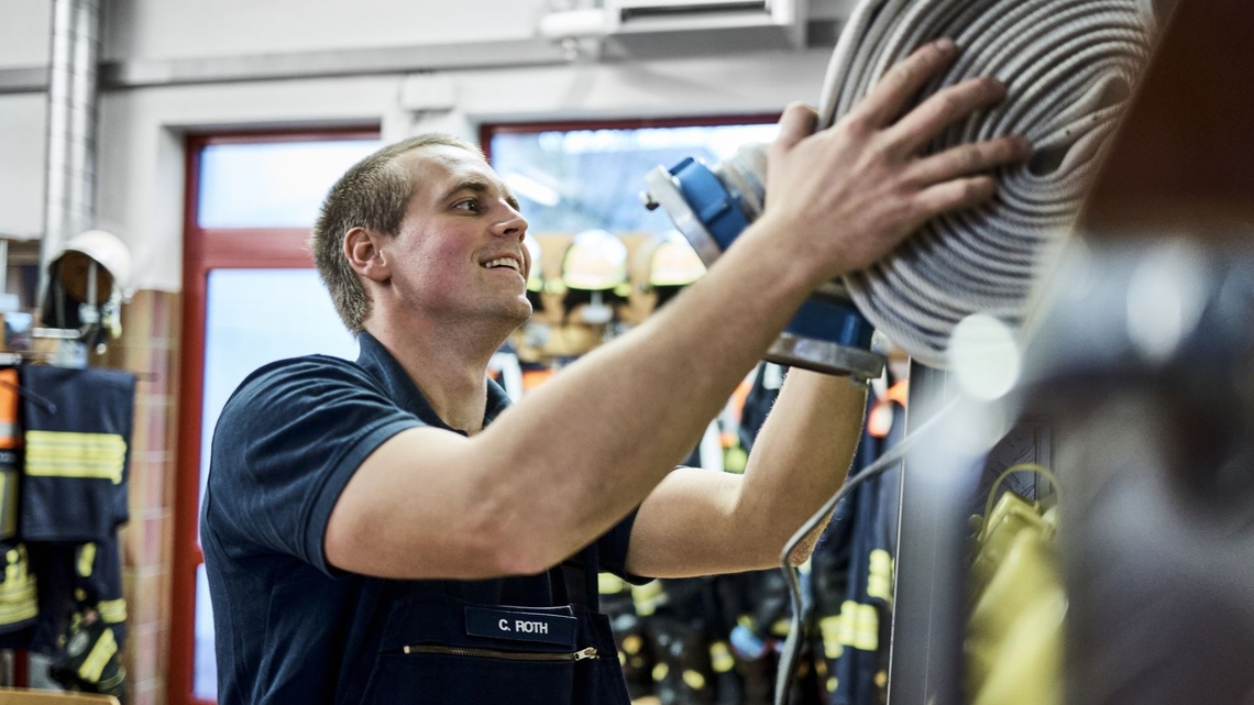 Firefighter Chris stows a fire hose.