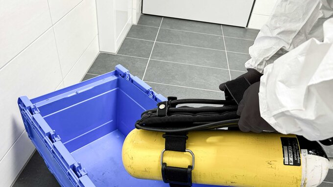 Atemschutzgerätewart nimmt Atemschutztechnik im Schwarzbereich zur Aufbereitung entgegen Atemschutzgerätewart nimmt Atemschutztechnik im Schwarzbereich zur Aufbereitung entgegen