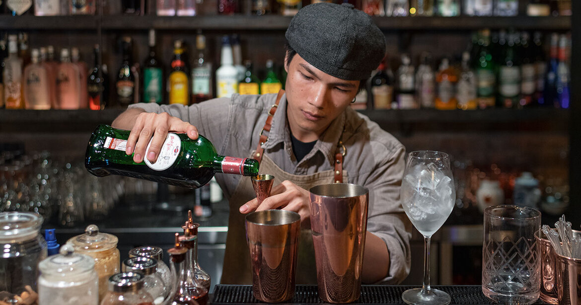 Bartender focuses on mixing cocktails Bartender focuses on mixing cocktails