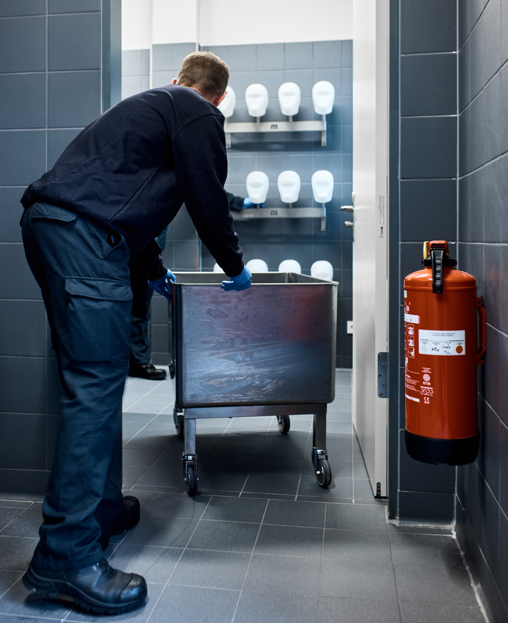 An SCBA technician brings a tray with PPE to be cleaned to the SCBA workshop