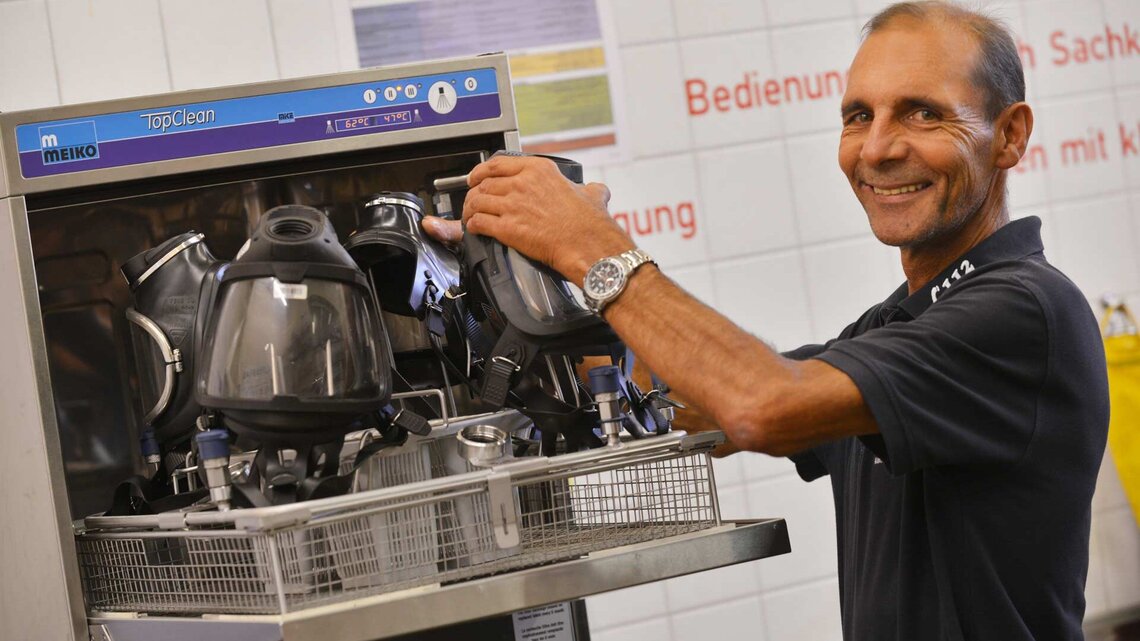 Atemschutzgerätewart bereitet Masken im Desinfektionsgerät TopClean-M auf