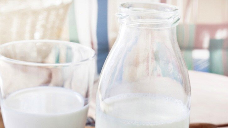 Milchflasche Halbvolle Milchflasche aus Glas