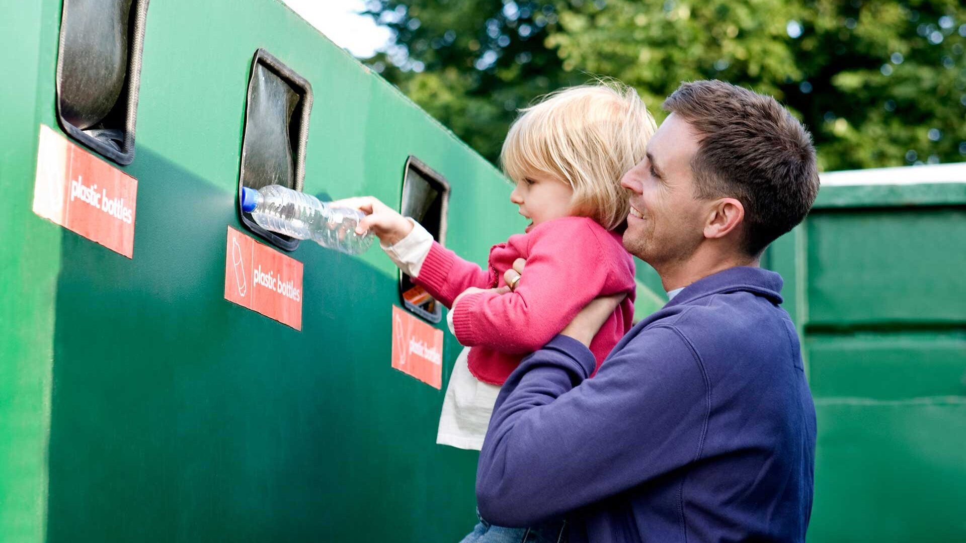 Vater zeigt Tochter, wie man Plastikflaschen recycelt