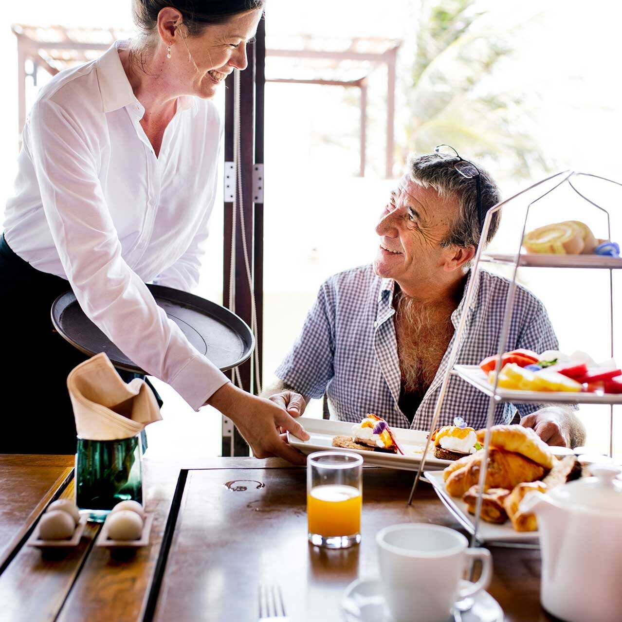 Une serveuse souriante sert un client Une serveuse aimable sert un client