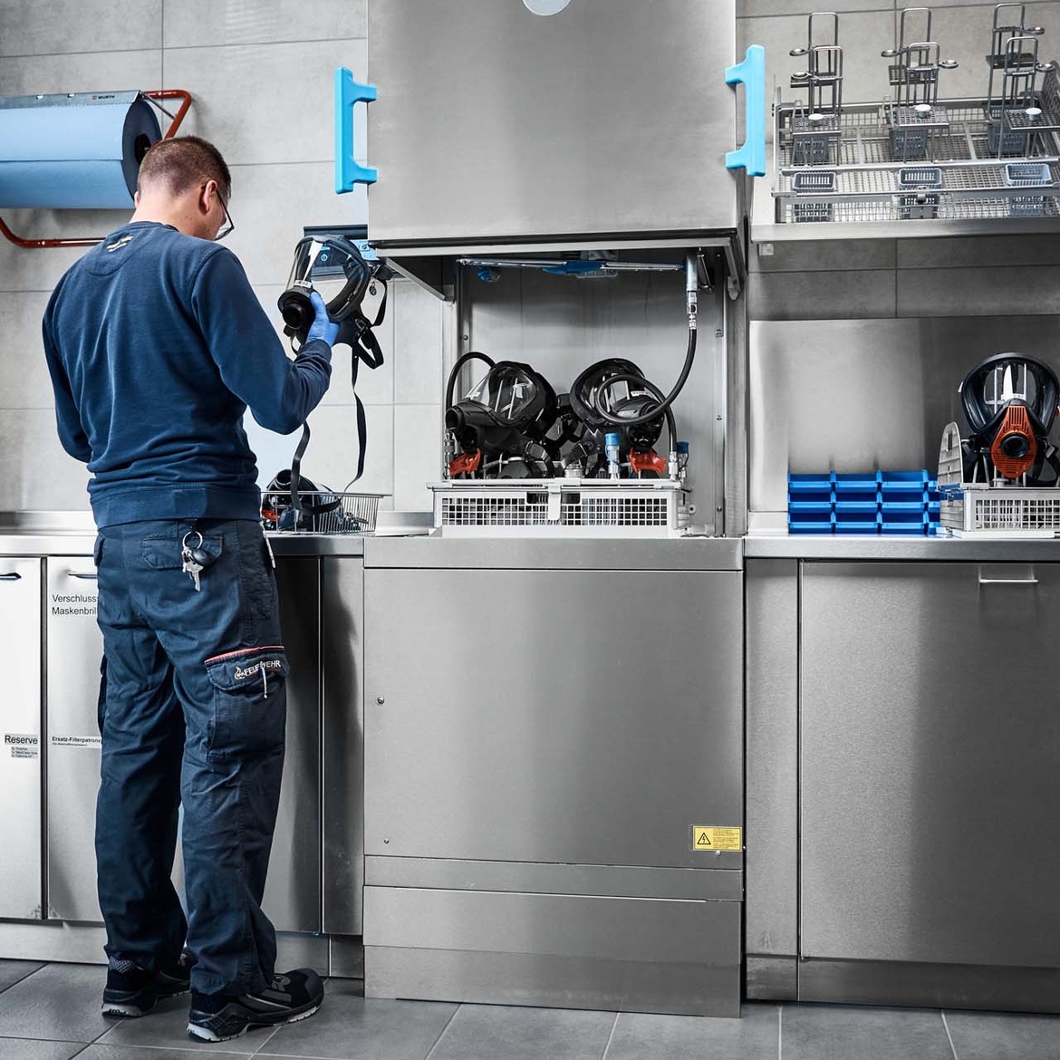 Nach Desinfektion entnimmt Atemschutzgerätewart die Masken aus dem TopClean H