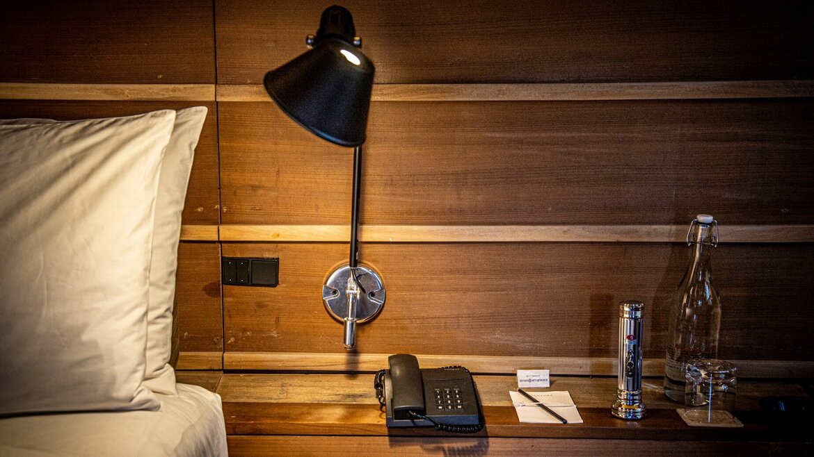 A glass bottle and a glass in a hotel bedroom A glass bottle and a glass in a hotel bedroom