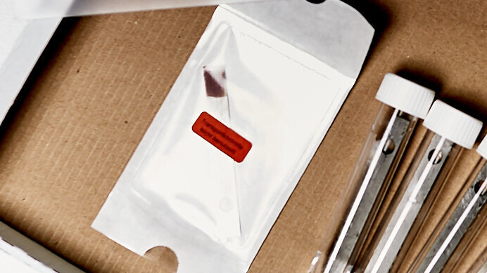 Einen von sechs Bioindikatoren als Transportkontrolle ungeöffnet in die Transportbox zurückgeben. Einen von sechs Bioindikatoren als Transportkontrolle ungeöffnet in die Transportbox zurückgeben.
