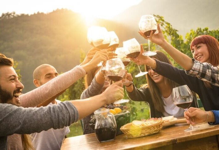 enoturismo ragazzi festeggiano bevendo vino