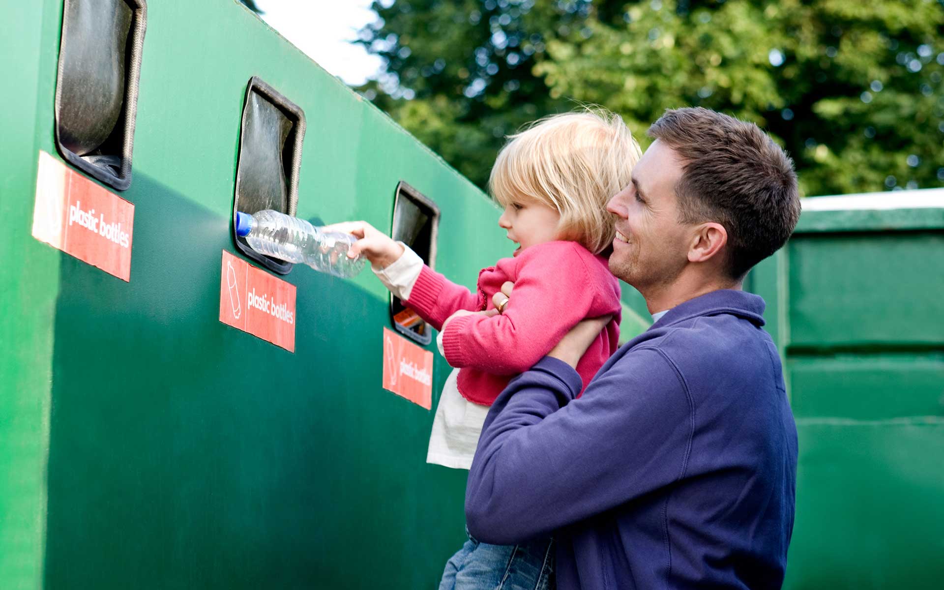 Mann und Kind recyceln eine Flasche