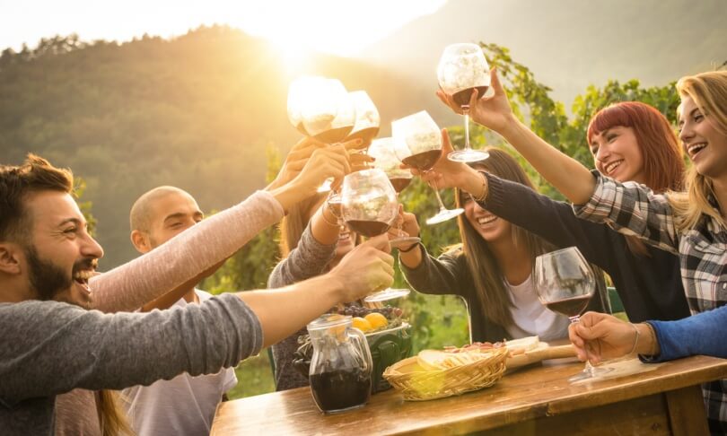 enoturismo ragazzi festeggiano bevendo vino